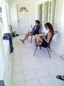 Porty Hostel في بورت أنطونيو: كانتا جالستين على كرسي في الشرفة