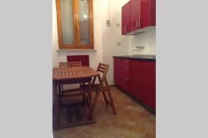 uma cozinha com uma mesa de madeira, uma mesa e cadeiras em La Casina del Vicolo em Marina di Campo