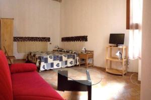 uma sala de estar com uma cama e uma mesa de vidro em La Casina del Vicolo em Marina di Campo