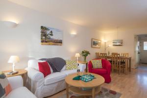 a living room with a couch and two chairs and a table at Blaeberry Cottage in Aviemore