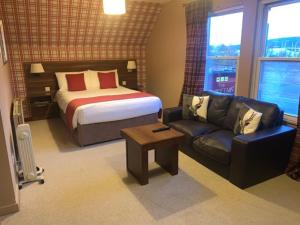 a hotel room with a bed and a couch at Chieftain Hotel in Inverness