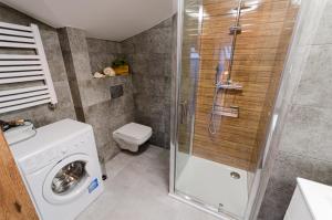 uma casa de banho com uma máquina de lavar roupa e um chuveiro em Bronowicka Premium Apartment - 52m2 with private parking na Cracóvia