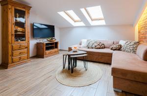 a living room with a couch and a tv at Bronowicka Premium Apartment - 52m2 with private parking in Kraków +29 photos