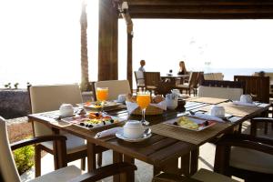 a wooden table with plates of food and orange juice at Dahab Paradise in Dahab