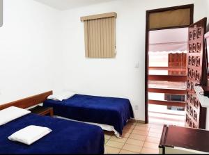 a hotel room with two beds and a window at HOTEL POUSADA ALAGOINHAS in Alagoinhas