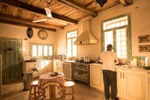 un hombre de pie en una cocina preparando comida en Barbara’s House, en Siwa