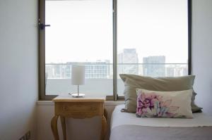 1 dormitorio con 1 cama con mesita de noche y ventana en Loica Suites III, en Santiago