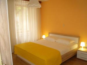 a yellow bedroom with a bed and a window at Apartma 2000 Tolmin in Tolmin