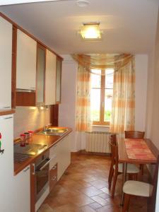 a kitchen with a table and a sink and a window at Apartma 2000 Tolmin in Tolmin