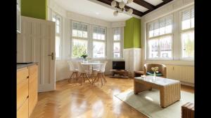 a kitchen with green walls and a table and chairs at Appartment im Villenviertel in Jena