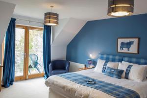 a bedroom with blue walls and a bed and a chair at Balachladaich Loch Ness B&B in Dores