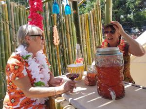 two women sitting at a table with a jar of liquid at The Luxury Honolulu with Private Bar at Paradise Valley Glamping in Kerikeri