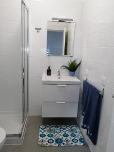 y baño con lavabo, espejo y ducha. en Estudio Vista Rubicon, en Playa Blanca