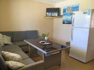 a living room with a couch and a white refrigerator at Jurien Beachfront Holiday Units in Jurien Bay