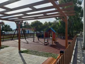 a park with a playground with a swing set at Soula's Sunshine Apartments in Néa Karváli