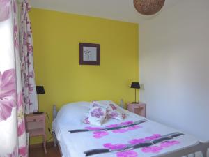 バニョール・ドゥ・ロルヌにあるBRUYERE D'ANDAINEのベッドルーム1室(花の飾られたベッド1台付)