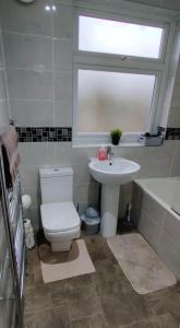 a bathroom with a toilet and a sink and a tub at Just Like Home in Bristol
