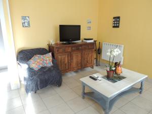 a living room with a tv and a coffee table at BRUYERE D'ANDAINE in Bagnoles de l'Orne