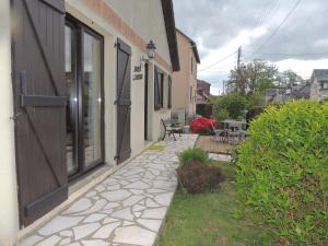 einen Fußweg neben einem Haus mit einer Terrasse in der Unterkunft BRUYERE D'ANDAINE in Bagnoles de l'Orne