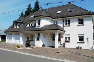 een groot wit huis met een zwart dak bij Lillie 3-4 Personen - Ferienwohnungen Wagner & Gaul Falkenauel in Falkenauel