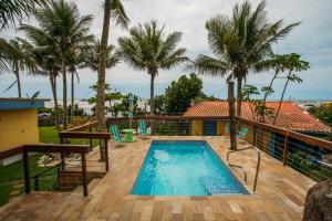 a swimming pool on top of a house with palm trees at Pousada Sobre as Pedras in Itanhaém