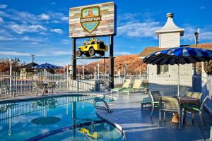 - un panneau avec une jeep à côté d'une piscine dans l'établissement Expedition Lodge Moab Arches National Park, à Moab