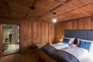 - une chambre avec un grand lit et des murs en bois dans l'établissement MESH-Mittereggerschneiderhof, à Panzendorf