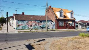 a building with graffiti on the side of it on a street at Patagonia House in Punta Arenas
