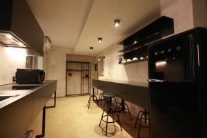 a kitchen with black counter tops and stools at Residenza Buglioni Piazza Erbe in Verona