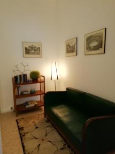 uma sala de estar com um sofá verde e um candeeiro em Le stanze di Ninni em Foligno
