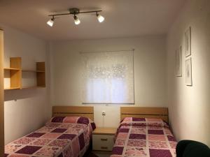 カディスにあるApartamento Santo Tomásのベッドルーム1室(ベッド2台、窓付)