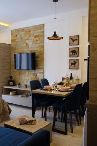 een eetkamer met een tafel en stoelen en een tv bij Ski & Spa Apartment S20 Milmari Resort Kopaonik in Kopaonik