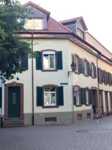 un bâtiment blanc avec volets verts dans une rue dans l'établissement Appartment Kornboden Nordic Style, à Schopfheim