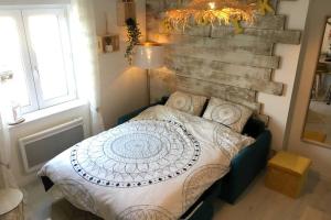 a bedroom with a bed and a brick wall at Un petit coin de paradis au centre ville de Caen in Caen