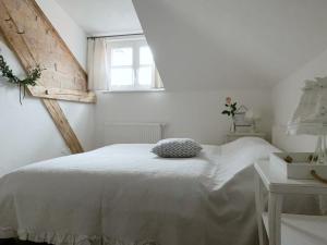 a white bedroom with a bed and a window at Appartment Kornboden Nordic Style in Schopfheim