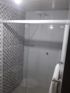 a shower with a glass door in a bathroom at Pouse Bem in Blumenau