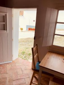 uma cozinha com uma mesa e uma porta para um quintal em Casas de Mértola 32 em Mértola
