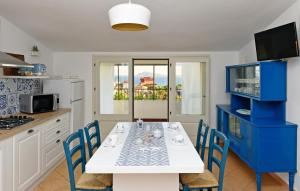 a kitchen with a white table and blue chairs at Appartamento BluMare in Santa Maria Navarrese +22 photos