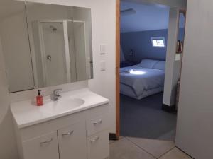 1 dormitorio con 1 cama y baño con lavabo. en Graceland B&B en Athol