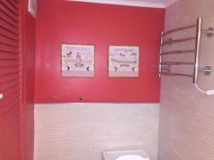 a red bathroom with a toilet and two pictures on the wall at Apartamento Libertador 1201 in Punta del Este