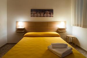 ein Schlafzimmer mit einem gelben Bett mit zwei Handtüchern darauf in der Unterkunft Angelsa Casa Vacanze in Marina di Modica