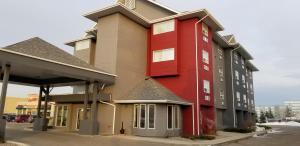 a red building on the side of a building at SureStay Plus Hotel by Best Western Lethbridge in Lethbridge