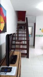 een kamer met een bureau, een televisie en een trap bij casa em condomínio com piscina in Maresias