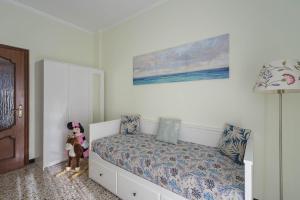 una camera da letto con un letto e un dipinto sul muro di Casa Dany, luminoso trilocale con grande terrazza e box auto a Santa Margherita Ligure