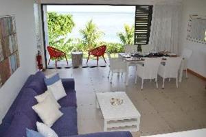 a living room with a couch and a table and chairs at Villasun Seafront Apart at CapOuest in Flic-en-Flac