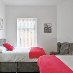 a bedroom with a bed with red sheets and a window at Priory Suites in Liverpool