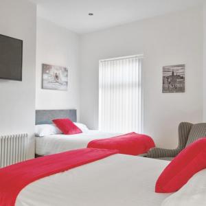 a hotel room with two beds with red pillows at Priory Suites in Liverpool