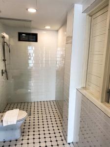 a bathroom with a toilet and a tiled shower at The Boutique Residence Hotel in George Town