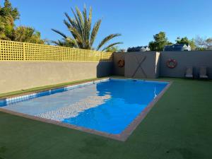 a swimming pool with blue water in a backyard at Capricorn Holiday Park in Carnarvon