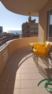 un balcón con sillas amarillas y una mesa en un edificio en Cebeci 2, en Mahmutlar